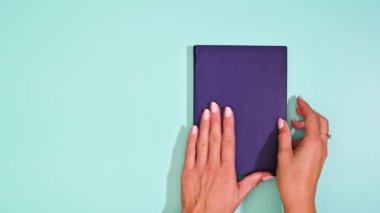 Kadın, Grace ile Boş Sayfayı Nane Yeşili arkaplan üzerine koyu mavi klasikler üzerine açıyor