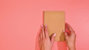 Kadın Boş Sayfa 'da Portakal Renkli Hardcover Kitabı' nı açıyor. Tek renkli konsept