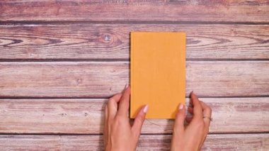 Kadınların Eli Masadaki Retro Hardcover Kitabı Döndürüyor