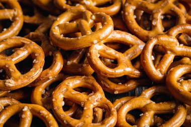 Salted mini pretzels texture background, small pretzels with salt, top view, close-up.