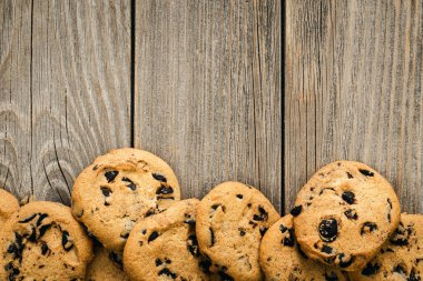 Traditional chocolate chip cookies on rustic wooden table, copy space, flat lay.