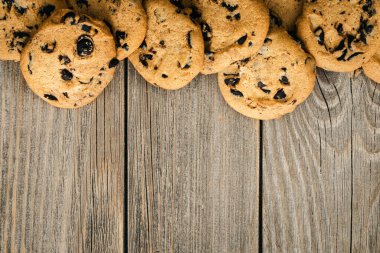 Traditional chocolate chip cookies on rustic wooden table, copy space, flat lay.