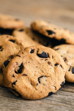 Close-up, chocolate crisp cookies on a rustic wooden background.