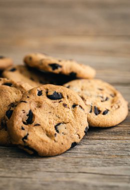 Close-up, chocolate crisp cookies on a rustic wooden background.