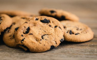 Cookies with chocolate crisps on a rustic wooden background, close-up.
