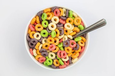 Colored breakfast cereal in a bowl on a white background, flat lay, childrens healthy breakfast, close up.