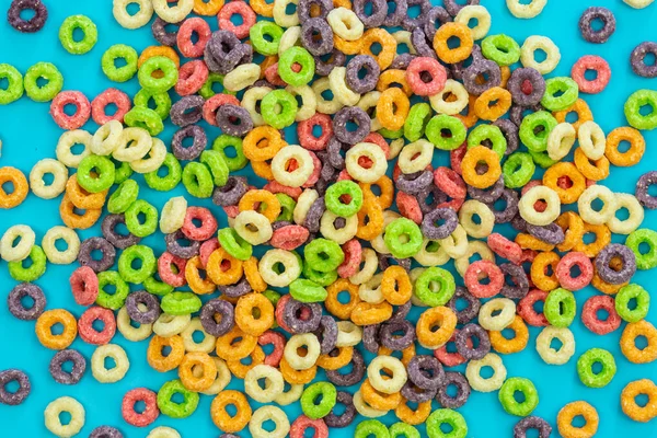 Background of round colorful cereal. Colorful breakfast food. Colorful cereal loop rings, flat lay.