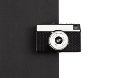 Old film camera on a black and white background, creative retro design, trendy vintage accessories, minimal flat lay.