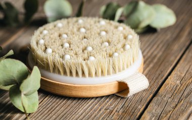 Tahta bir yüzeyde kuru masaj için bir bambu fırçasının kapağını kapatın, spa ve rahatlama araçları.