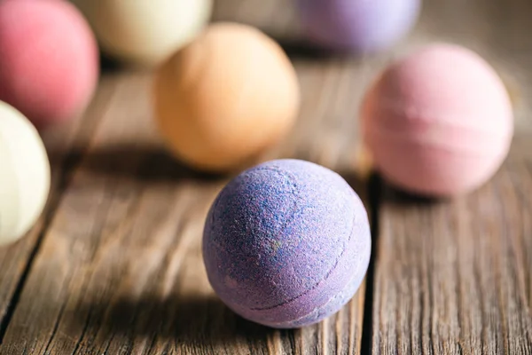Multi-colored bath bombs on a wooden background close-up, the concept of hygiene and aesthetics.