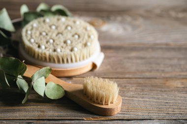 Tahta bir yüzeye kuru masaj için banyonun bambu fırçalarını kapayın, spa ve rahatlama araçları, kopyalama alanı.