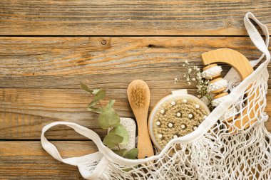 Masaj fırçaları ve hijyen malzemeleri ile kaplıca kompozisyonu ahşap bir arka planda, üst görünüm, eko konsepti.