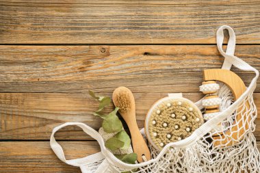 Masaj fırçaları ve hijyen malzemeleri ile kaplıca kompozisyonu ahşap bir arka planda, üst görünüm, eko konsepti.