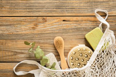 Masaj fırçaları ve hijyen malzemeleri ile kaplıca kompozisyonu ahşap bir arka planda, üst görünüm, eko konsepti.