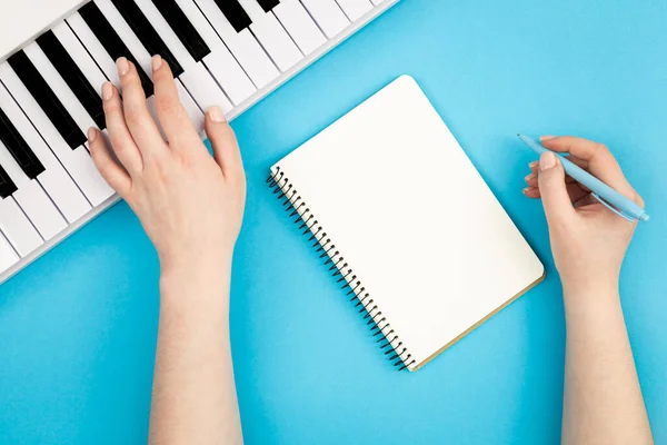 Manos Femeninas Cuaderno Blanco Teclas Música Sobre Fondo Azul Planas — Foto de Stock