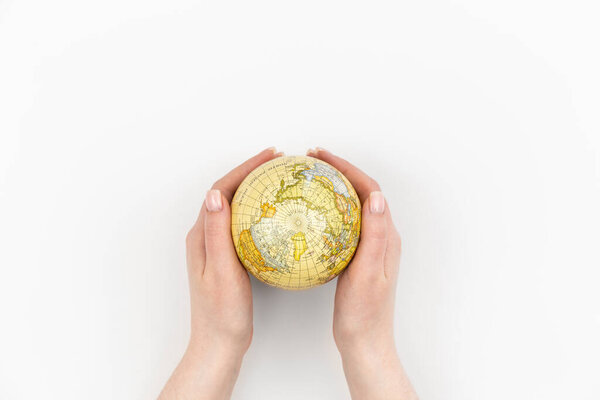 Земной шар в женских руках на белом фоне изолирован, вид сверху, концепция Дня Земли, забота о планете.