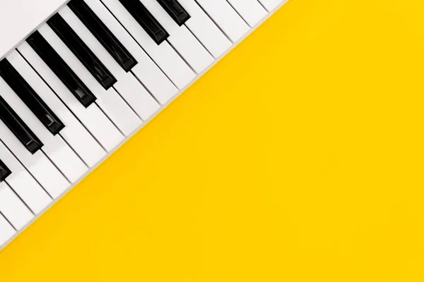 黄色背景上的钢琴键 顶部视图 平面布局 复制空间 — 图库照片