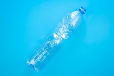 Mavi arka planda kullanılmış plastik şişe, üst manzara, düz yatak. Plastik kullanma kavramı. Çevresel sorun, küresel çevre sorunu, kopyalama alanı.