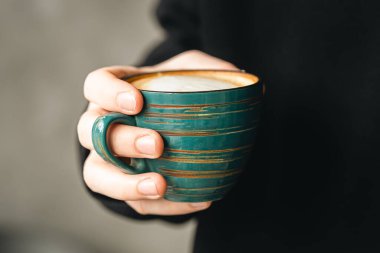 Seramik yeşil el yapımı kahve erkek ellerinde, yakın plan, sabah işte, kapuçino yakın plan kahve dükkanında..