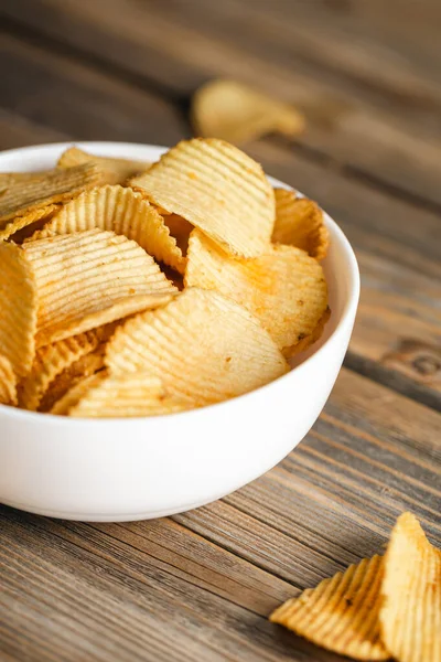 stock image Potatoes chips in bowl good for snack for beer or ale on a natural wooden table. Good for beer festival, pub, restaurant advertising.