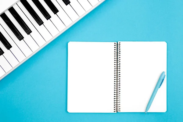 Blankes Notizbuch Und Klavier Auf Blauem Hintergrund Draufsicht Konzept Der — Stockfoto