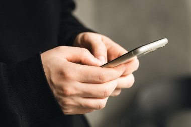 Bulanık bir geçmişi olan bir adamın elindeki akıllı telefon teknolojiyi kullanma, internetten alışveriş yapma ve uzaktan iletişim kurma kavramı..