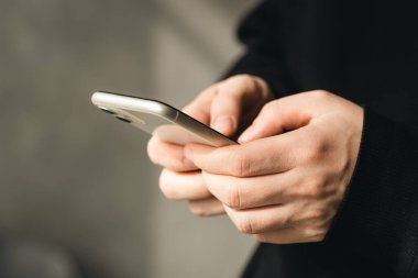 Bulanık bir geçmişi olan bir adamın elindeki akıllı telefon teknolojiyi kullanma, internetten alışveriş yapma ve uzaktan iletişim kurma kavramı..