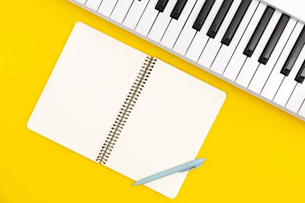 黄色の背景 音楽的創造性の概念 コピースペースのピアノとノートブック — ストック写真