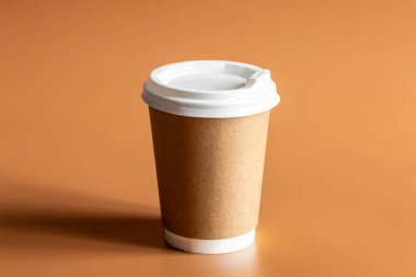 Sıfır Atık Yaşam Tarzı, Tek Kullanılabilir Kahverengi Kupa Beyaz Plastik Lid ile kahverengi arka plan izole.