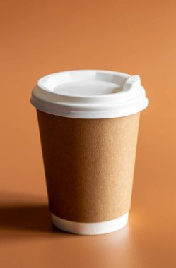 Sıfır Atık Yaşam Tarzı, Tek Kullanılabilir Kahverengi Kupa Beyaz Plastik Lid ile kahverengi arka plan izole.