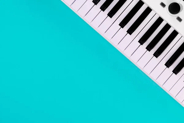 ピアノとフラットレイアウトの背景 青の背景に白いシンセサイザー 孤立した音楽キー トップビュー コピースペース — ストック写真