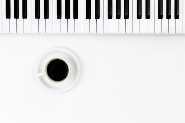白い背景に音楽キーボードとコーヒーカップ フラットレイアウト テキストのためのスペース ミニマリズム音楽の背景 概念的ミニマリズム — ストック写真