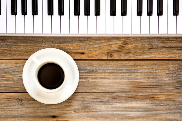 Klaviertasten Und Eine Tasse Kaffee Auf Einem Hölzernen Hintergrund Draufsicht — Stockfoto