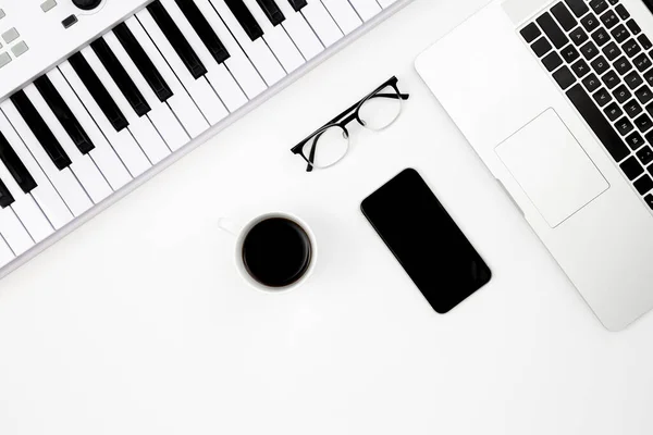 スマートフォン コーヒーカップ 音楽用電子キー ノートパソコンを背景にした音楽の静物画 トップビュー 音楽制作 販売のコンセプト — ストック写真