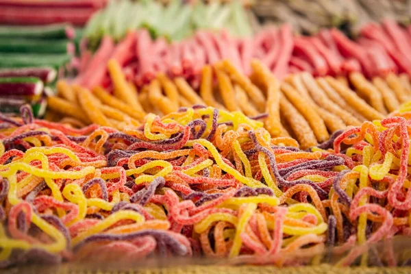 Assorted gummy candies and jellies on street market shop, colorful laces sweets, candies background.