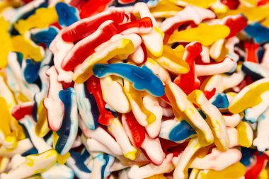 Yunuslar şeklinde çiğnenmiş jelatin tatlıların arka planı, yakın plan..