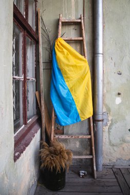 Ulusal Ukrayna bayrağı ve eski bir evin balkonunda tahta bir merdiven, vatanseverlik kavramı, ulusal bir sembol..