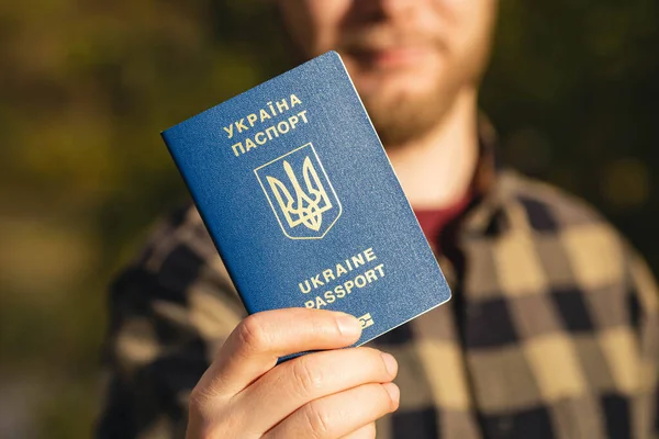Bir Ukrayna vatandaşının pasaportu erkeklerin elinde, yakın plan, göç kavramı.