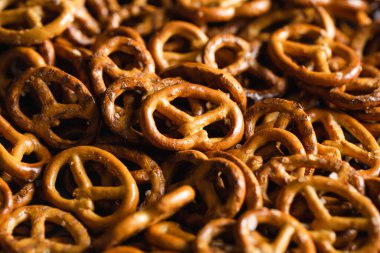 Salted mini pretzels texture background, small pretzels with salt, top view, close-up.