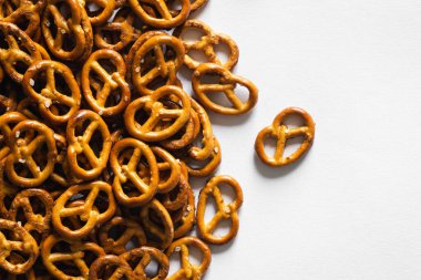 Beyaz zemin üzerinde tuzlu mini krakerler izole, üst görünüm.