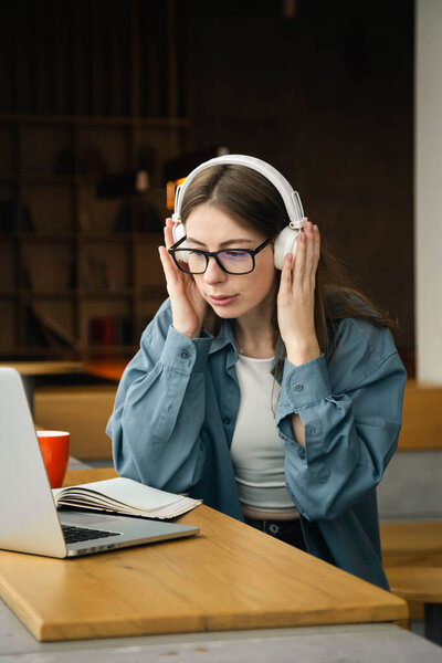 Portrait of woman sitting at desk, using laptop, watching tutorial, lecture or webinar, studying online.