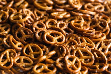 Salted mini pretzels texture background, small pretzels with salt, top view, close-up.