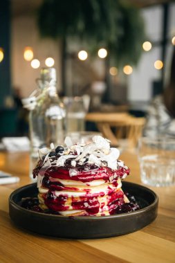 Vanilyalı krep, taze böğürtlen, fındık, hindistan cevizi ve reçel bir kafede yakın plan, lezzetli bir kahvaltı..