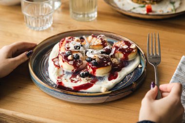 Taze böğürtlenli peynirli krep, fındık ve hindistan cevizi cipsi, lezzetli kahvaltı, Ukrayna mutfağı..
