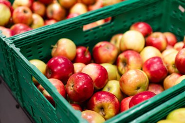 Markette meyveler var. Yiyecek pazarının tezgahında bir sürü kırmızı ve sarı elma var. Mağaza rafında fazladan elma var. Market alışverişi. Elma hasatı Ekolojik tarım kavramı.