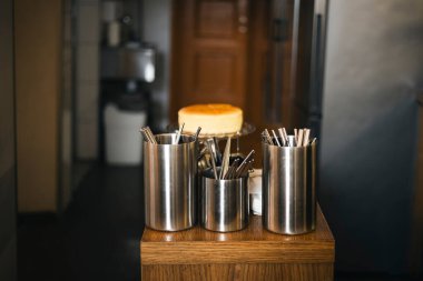 Kafenin mutfağında çatal bıçaklı metal kutular. Temiz tabakları olan bir bar tezgahı. Lokantadaki bar, çalışmaya hazır. Kafe arka planı. Mutfak gereçleri, kafe barında yemek malzemeleri..