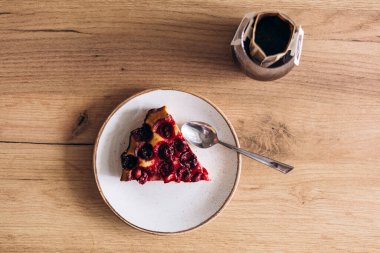 Ev yapımı vişneli turta ve ahşap masaya damlatan kahve. Kahvaltı, tatlı ya da yavaş yaşam temaları için mükemmel kompozisyon.