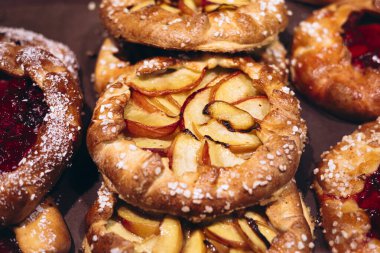 Fırında sergilenen birkaç taze şeftali galerinin yakın çekim görüntüsü. Altın kabuklar ve canlı şeftali dilimleri ev yapımı bir tatlı sunumu yaratır..