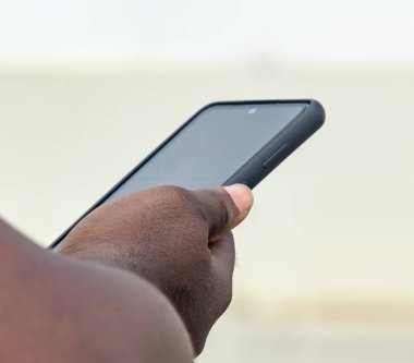 Siyah akıllı telefon tutan Afrikalı işadamı