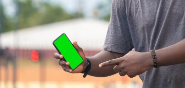 Beyaz beyaz ekran akıllı telefon tutan Afrikalı genç bir adamın eli